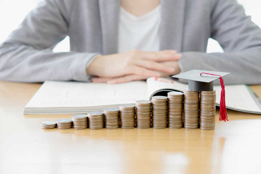 coins with graduation hat and a woman at the backgroun