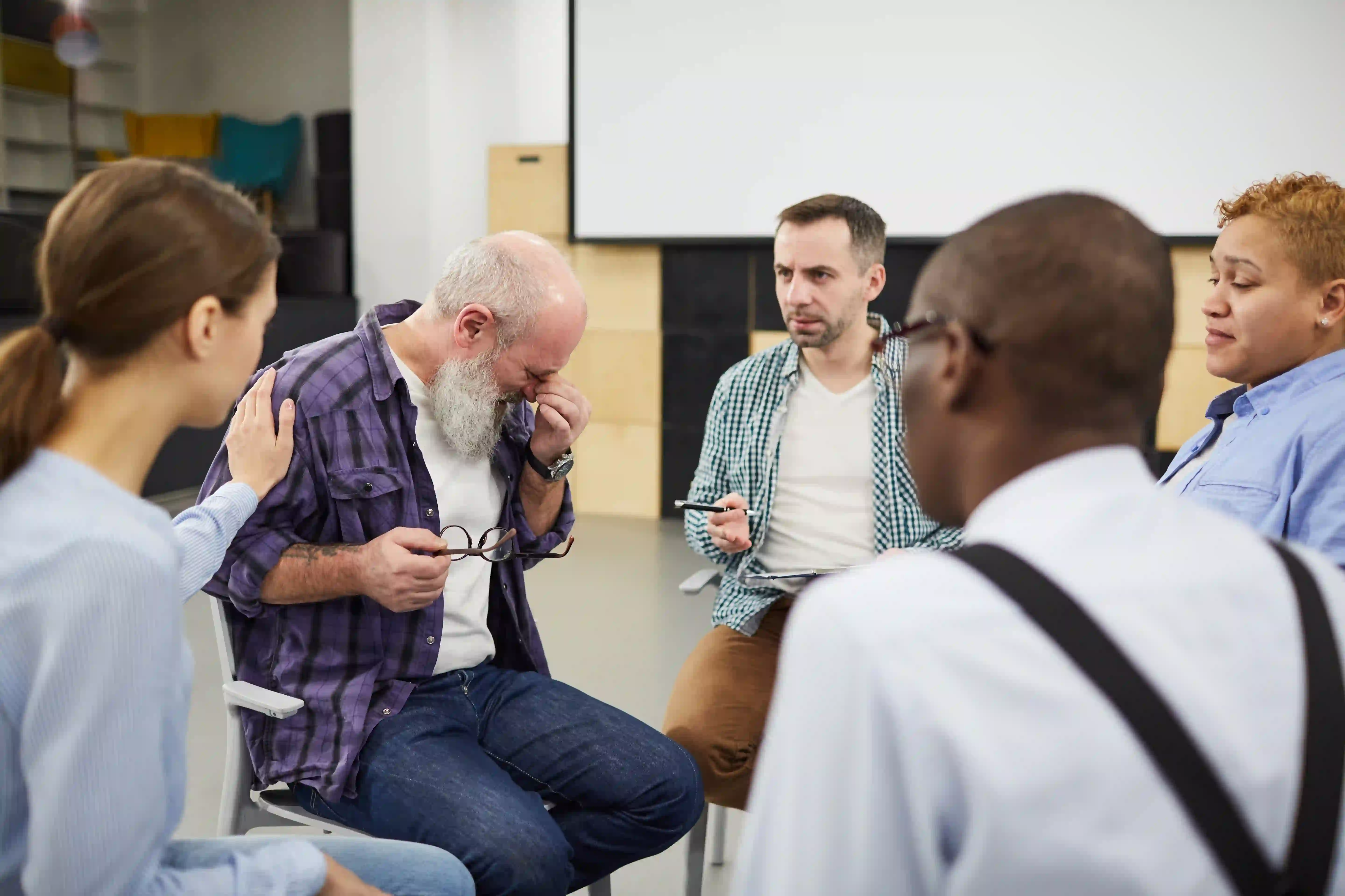 man crying in support group meeting