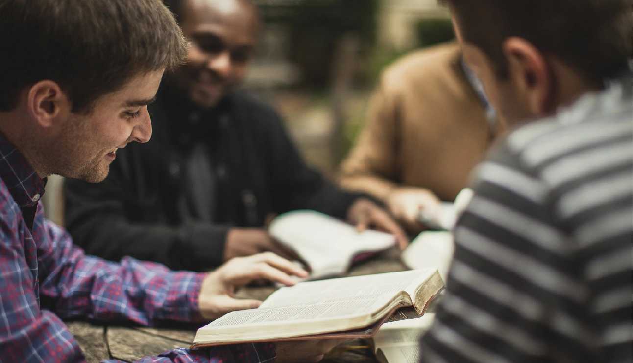 Men holding Bible and discussing