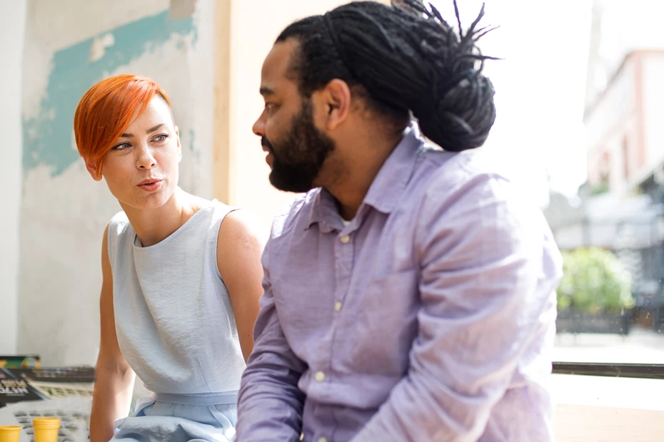 multiracial couple sitting and talking to each other