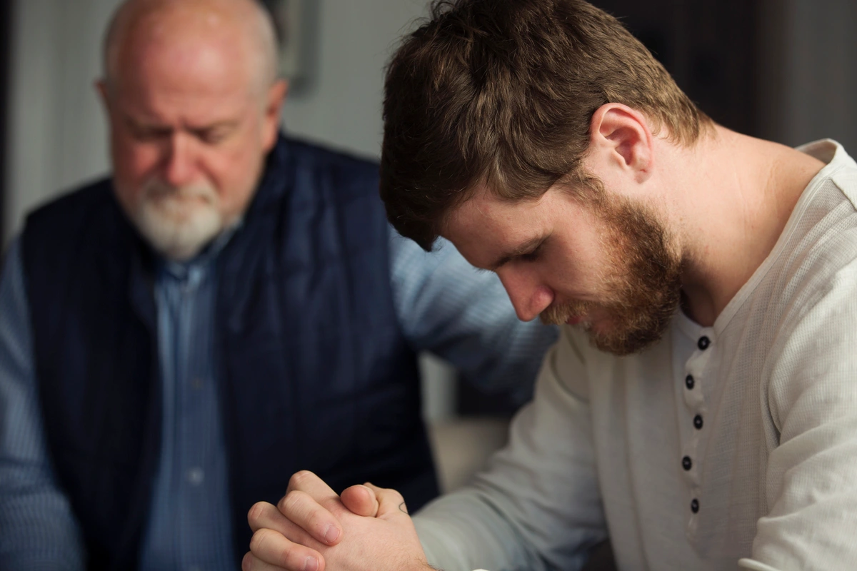 2 men bowing head and closing eyes