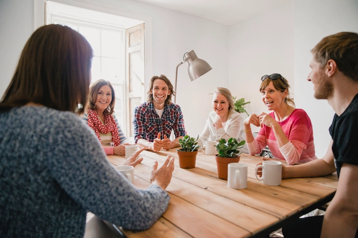 Adult laughing around a table
