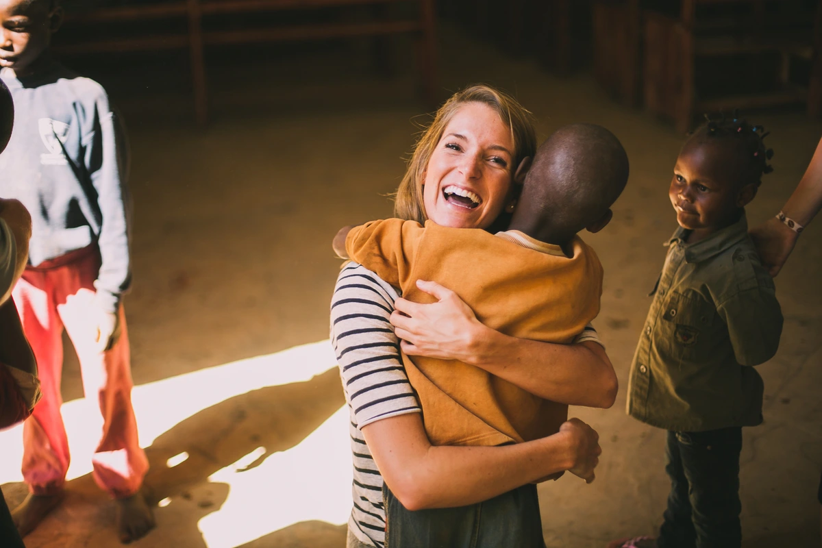 white woman hugging black child